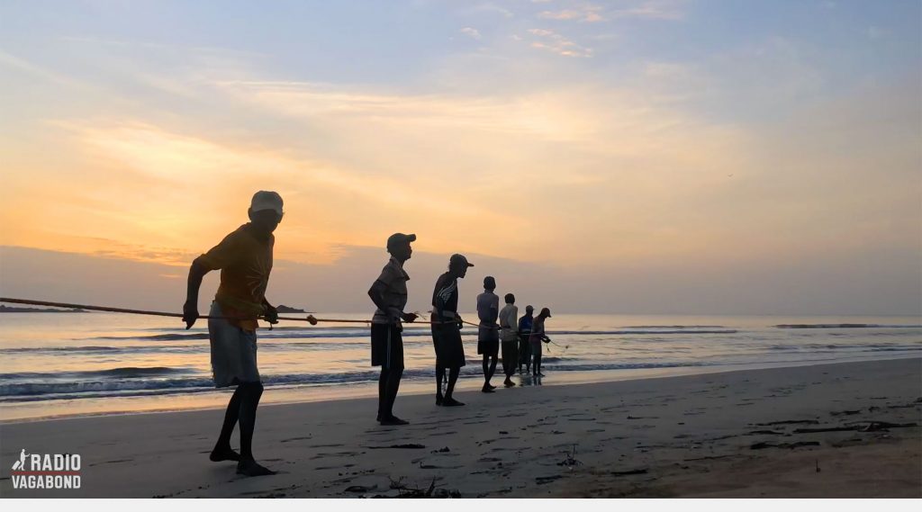 Eleven young men were walking into my shot, pulling a net full of fish out of the water.