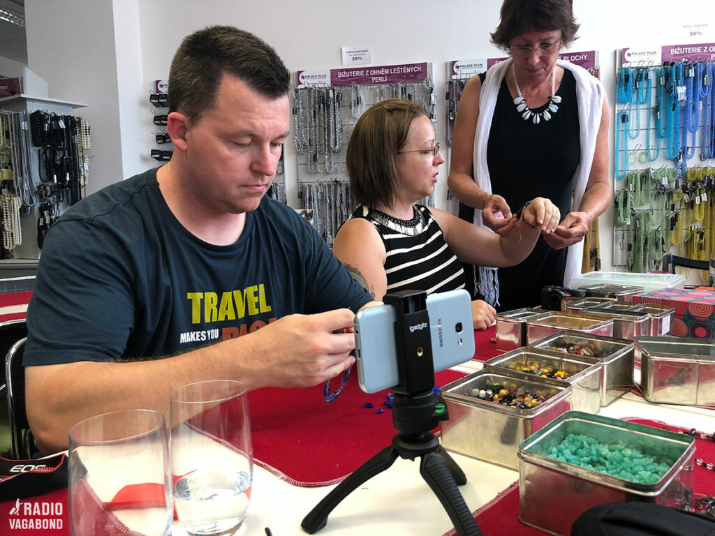 Focussed travel bloggers threading beads.